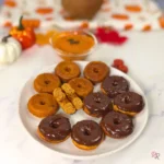 Coconut flour pumpkin donuts with cottage cheese, mix of plain and chocolate glazed, shot with fall decor.