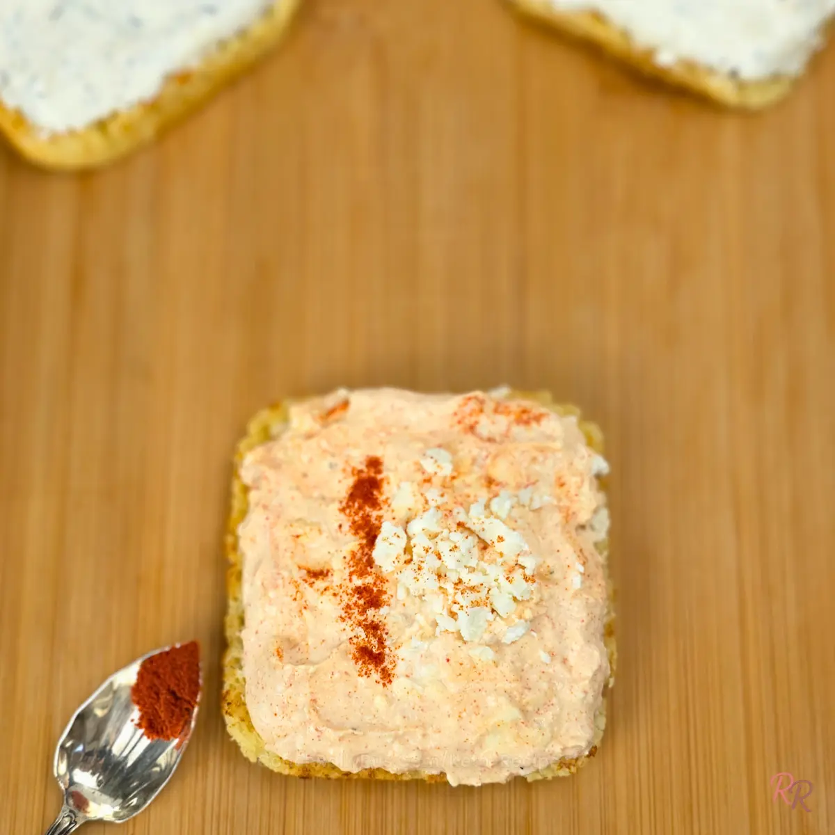 Feta and paprika whipped cottage cheese spread on keto flatbread with a spoonful of paprika