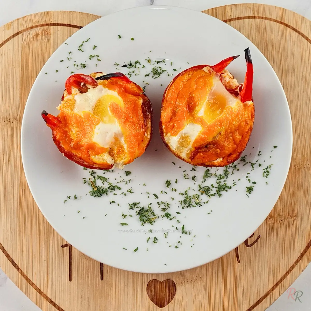 Low Carb Breakfast Egg Muffins with Pepperoni Two keto breakfast muffins with visible egg centers on white plate over wood board