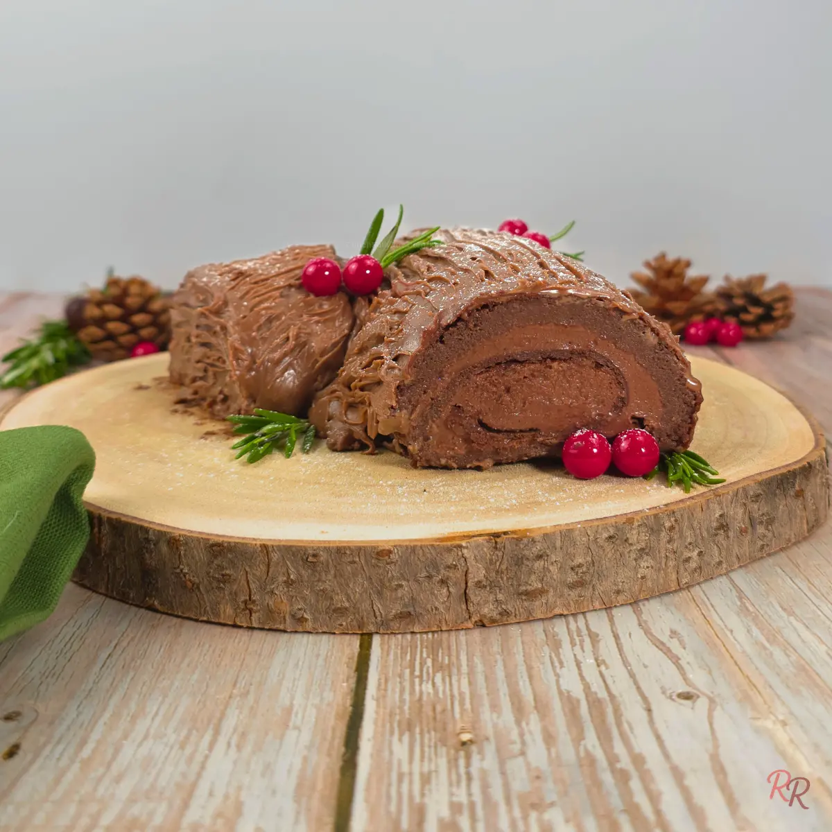 Side view of yule log cake on marble background with powdered sweetener dusted on top.