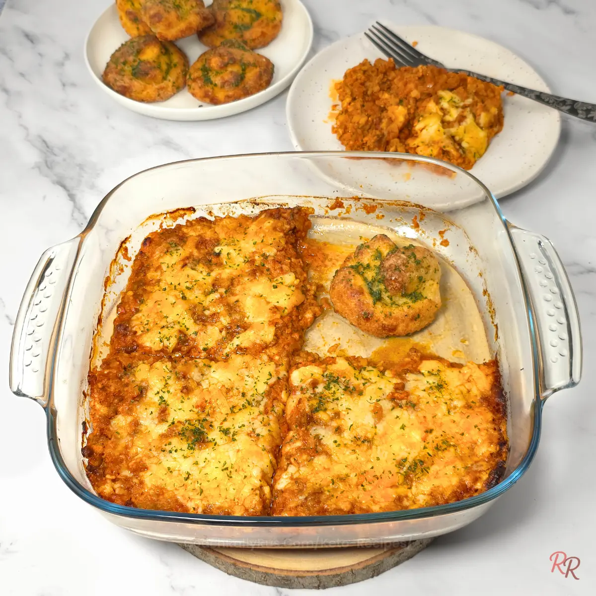 Sliced keto taco casserole with garlic knots and plated serving