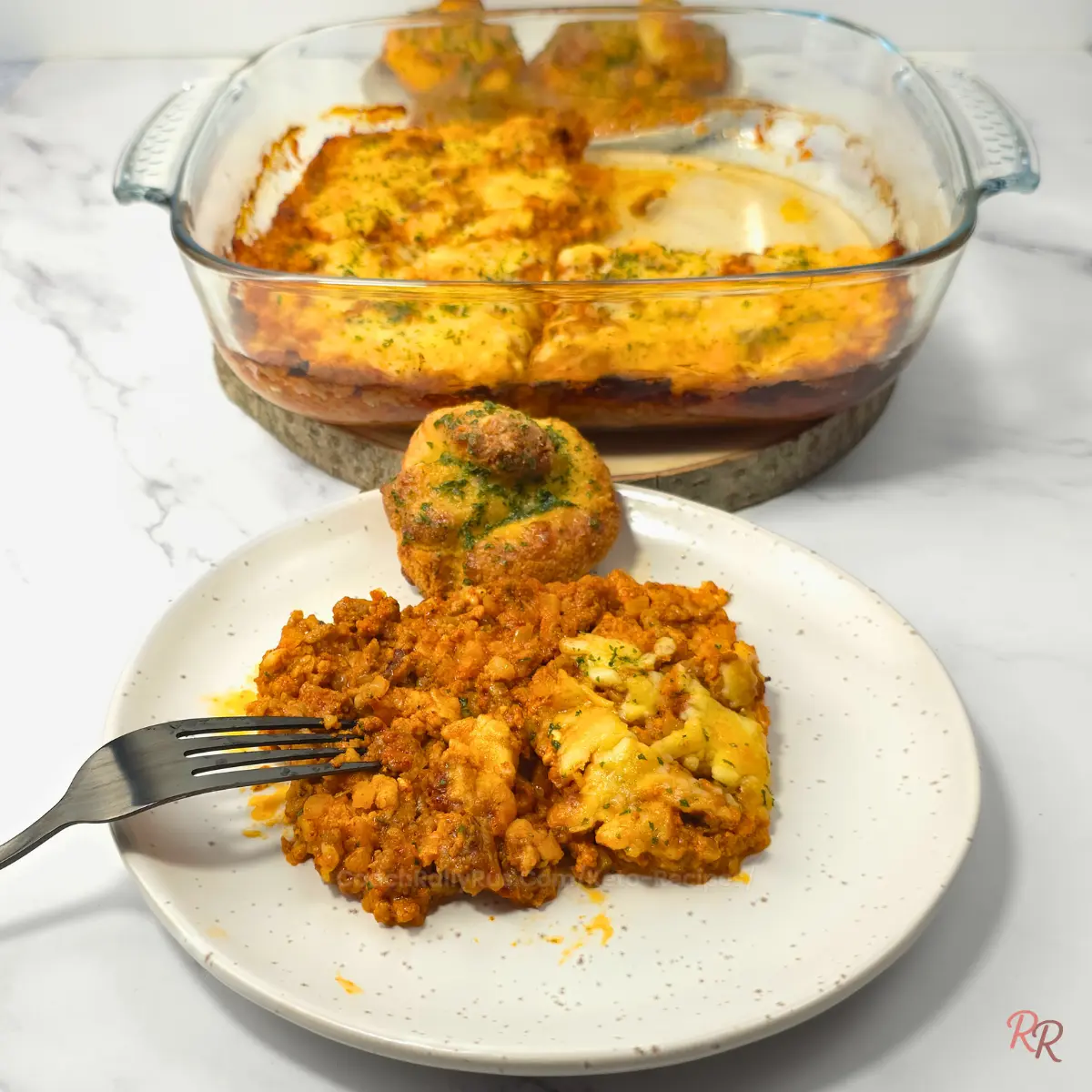 Fork tucked into cheesy keto taco casserole with garlic knot