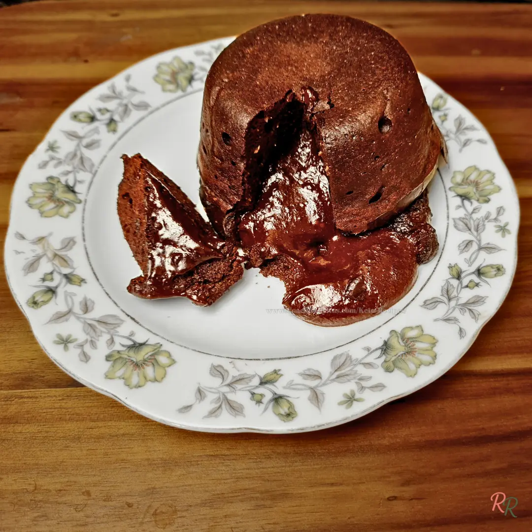 Single-Serve Keto Chocolate Lava Cake Full view of keto chocolate lava cake on a white and yellow floral plate, with rich molten chocolate flowing from the center