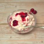Creamy keto cranberry cottage cheese fluff in a small glass bowl with visible cranberry swirls on top.
