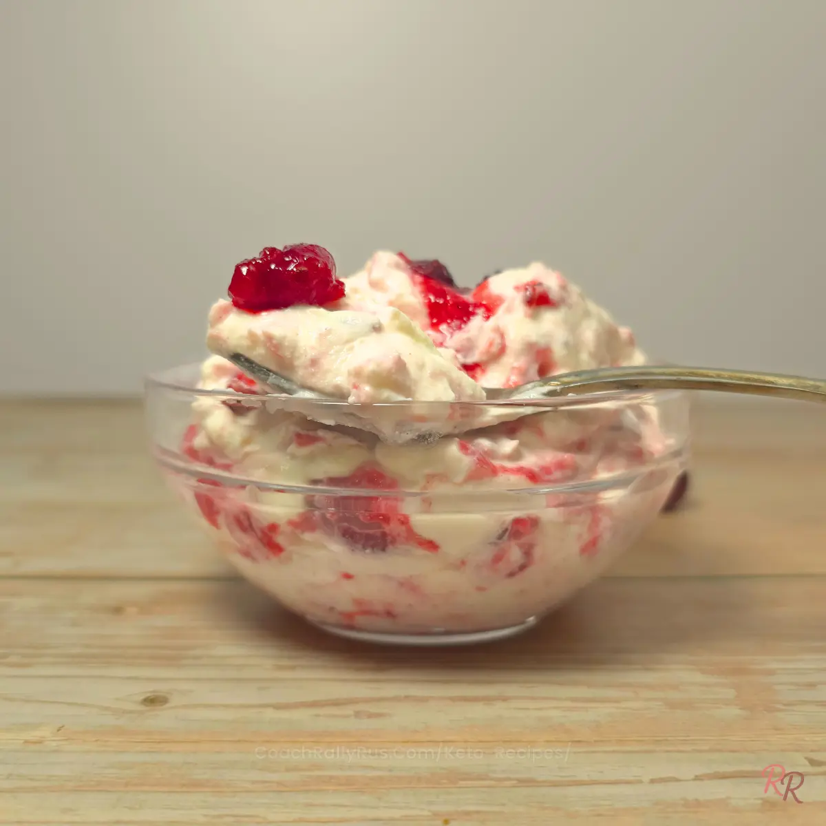 Low Carb Cranberry Cottage Cheese Fluff Side view of keto cranberry cottage cheese fluff topped with sugar-free cranberry sauce in a clear bowl.