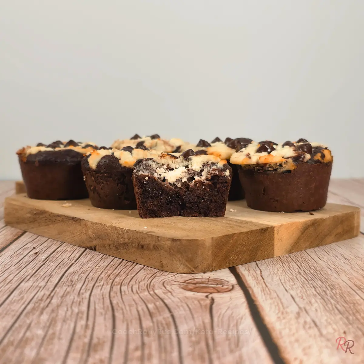 Keto brookie muffins on a wooden board, one cut to show inside.