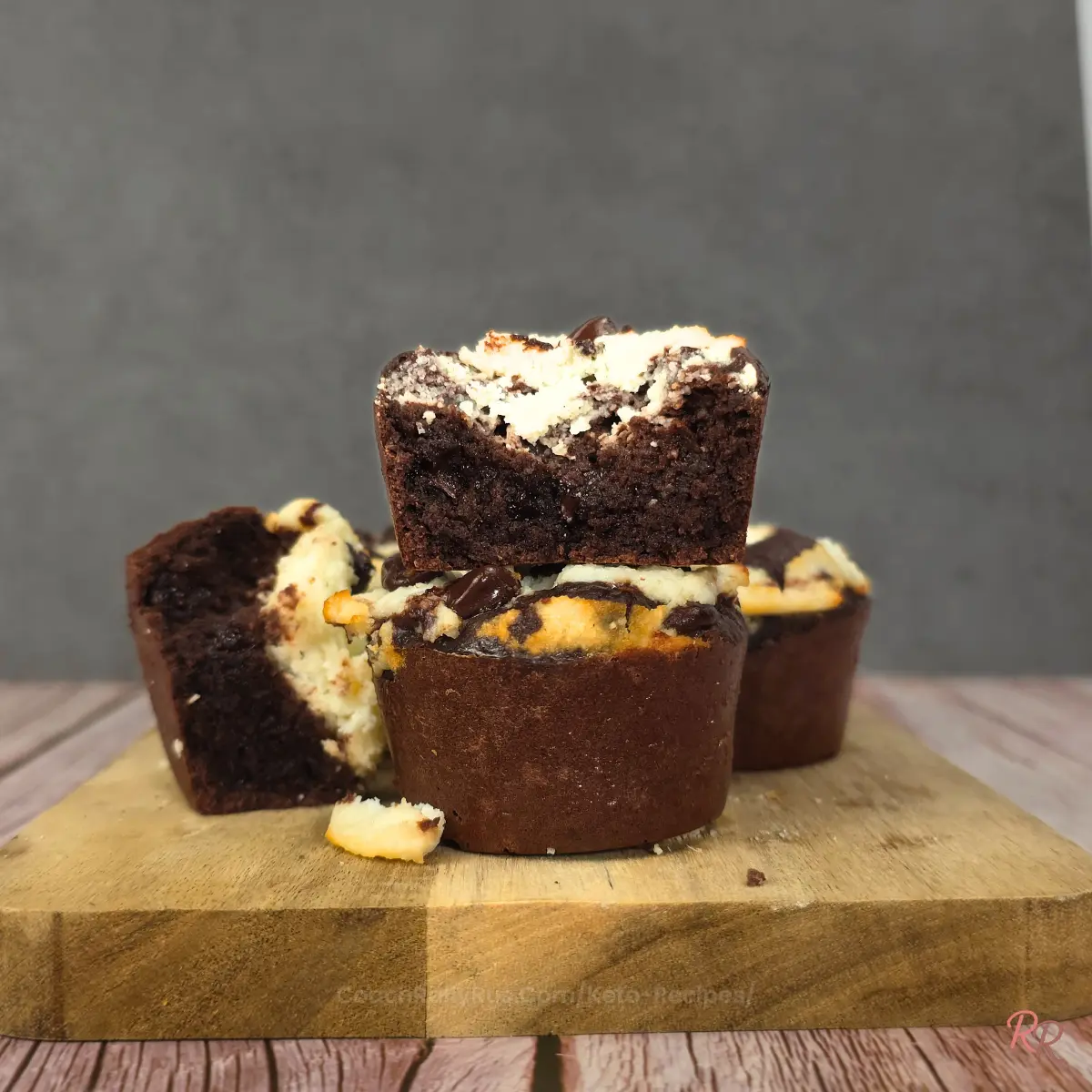 Stacked keto brookie muffins with one sliced to show inside.