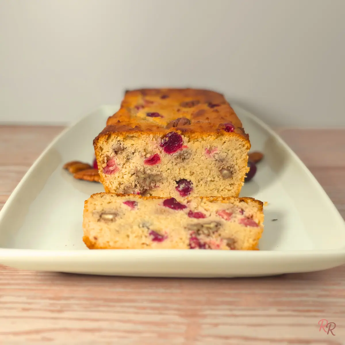 Sliced keto cranberry bread with pecans showing the soft cottage cheese crumb