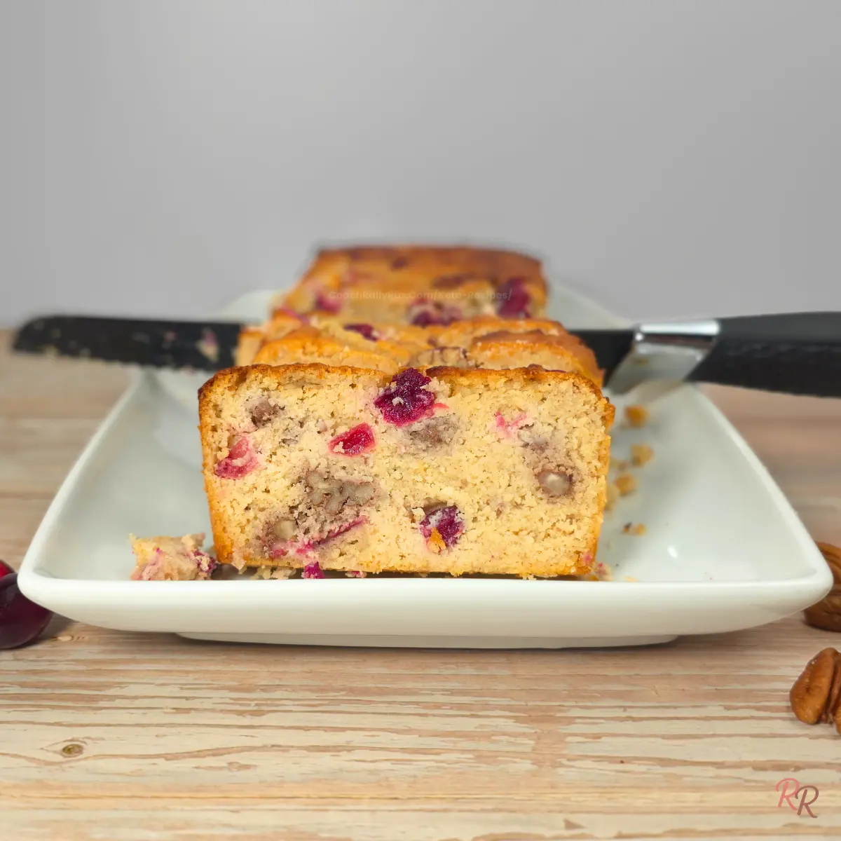 Close-up of a slice of keto cranberry bread with pecans and cottage cheese