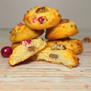 Soft keto cranberry cottage cheese cookie broken in half, showing a tender crumb with chopped pecans and cranberries inside