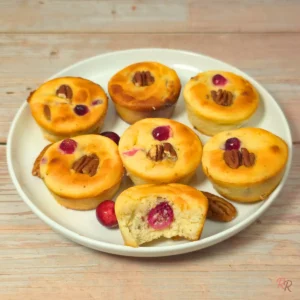 Plate of keto cranberry pecan cottage cheese breakfast muffins with one muffin cut open