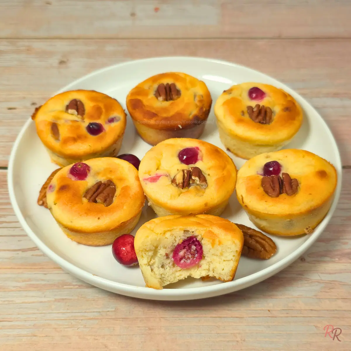 High Protein Keto Cranberry Pecan Cottage Cheese Breakfast Muffins Plate of keto cranberry pecan cottage cheese breakfast muffins with one muffin cut open