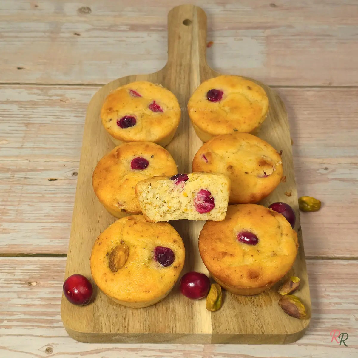 Gluten Free Cranberry Pistachio Cottage Cheese Muffins Keto cranberry pistachio cottage cheese muffins on a wooden board with a sliced muffin showing the crumb