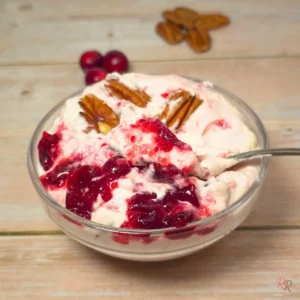 Keto cranberry cottage cheese salad with pecans in a glass bowl, creamy pink texture with cranberry swirl.