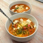 Keto lasagna soup in a bowl with mozzarella, blended cottage cheese, and parsley on top