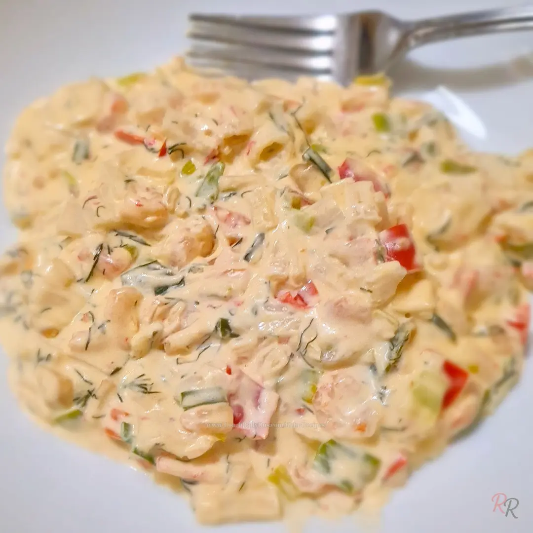 Creamy keto garlic shrimp in a skillet-style sauce with dill, green onions, and red bell pepper, served on a white plate.