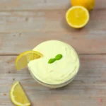 Lemon cottage cheese Alfredo sauce in a glass bowl with a lemon wedge
