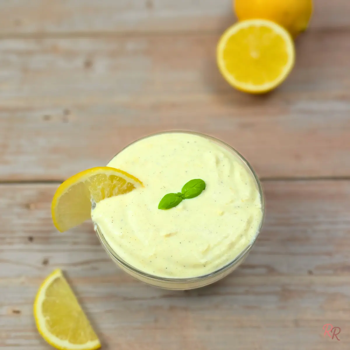 Lemon cottage cheese Alfredo sauce in a glass bowl with a lemon wedge